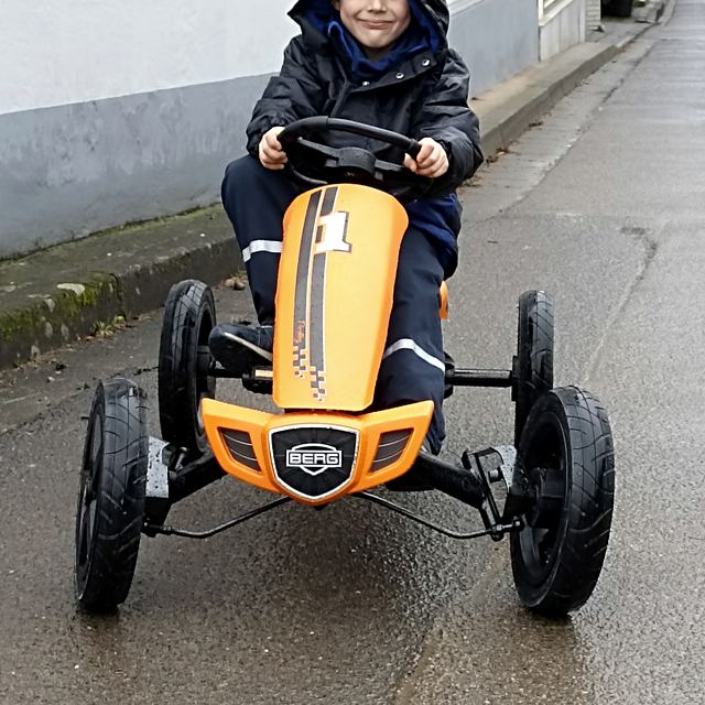 Maximilian im orangefarbenen Tretkart