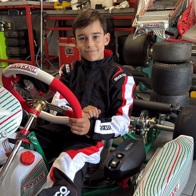 Maximilian im Rennoverall am Lenkrad des Tony Kart